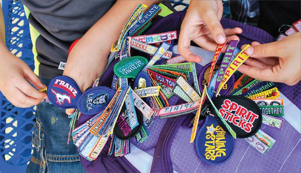 Spirit Stick charms clipped to a backpack